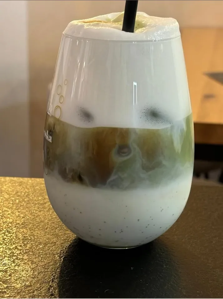 Un bicchiere alto di caffe' freddo a strati con la crema chiara sopra
